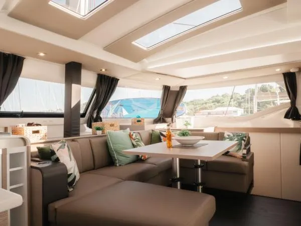 Sea The World Yacht Photos Pics Luxurious interior of 2023 Fountaine Pajot Elba 45 catamaran with modern seating and dining area.