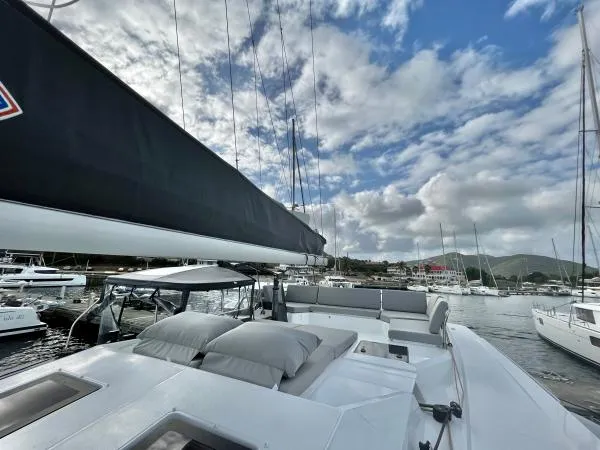 Sea The World Yacht Photos Pics 2023 Fountaine Pajot Elba 45 catamaran docked in a marina under a partly cloudy sky.