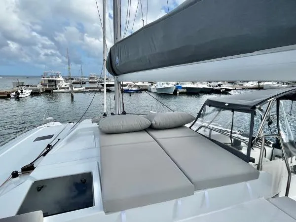 Sea The World Yacht Photos Pics 2023 Fountaine Pajot Elba 45 catamaran with cushioned deck, docked at marina.