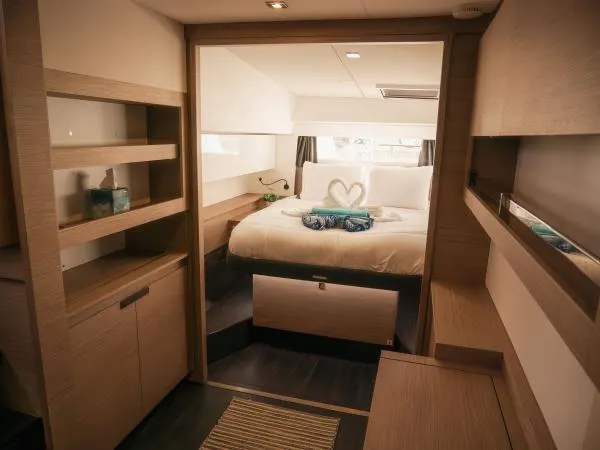 Sea The World Yacht Photos Pics Luxurious cabin interior of 2023 Fountaine Pajot Elba 45 catamaran, featuring elegant wood finishes.