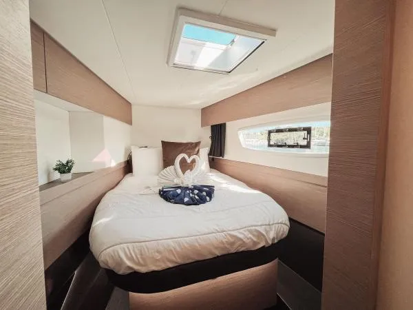 Sea The World Yacht Photos Pics Luxurious cabin interior of 2023 Fountaine Pajot Elba 45 catamaran with elegant bedding.