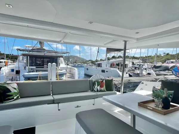Sea The World Yacht Photos Pics 2023 Fountaine Pajot Elba 45 catamaran interior with marina view, featuring modern seating and decor.