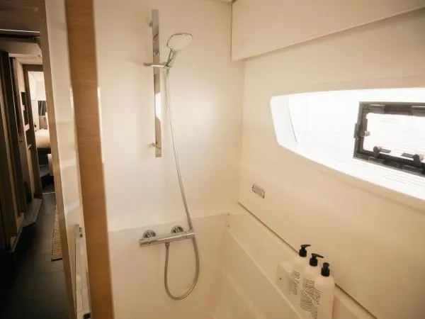 Sea The World Yacht Photos Pics Modern shower area in 2023 Fountaine Pajot Elba 45 yacht, featuring sleek design and window.