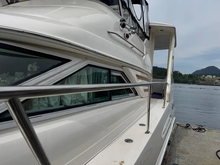  Yacht Photos Pics 1998 Sea Ray 420 Aft Cabin yacht docked by a scenic waterfront.