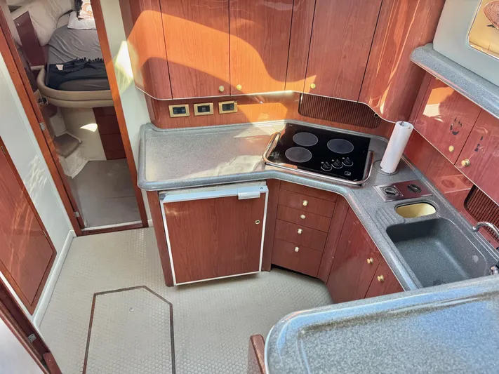  Yacht Photos Pics 1998 Sea Ray 420 Aft Cabin kitchen with stove, sink, and wood cabinetry.