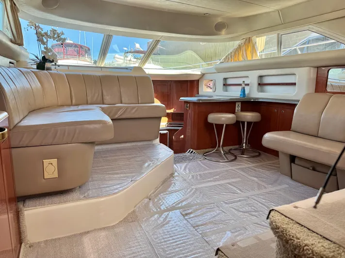  Yacht Photos Pics Luxurious interior of 1998 Sea Ray 420 Aft Cabin yacht with plush seating and bar stools.