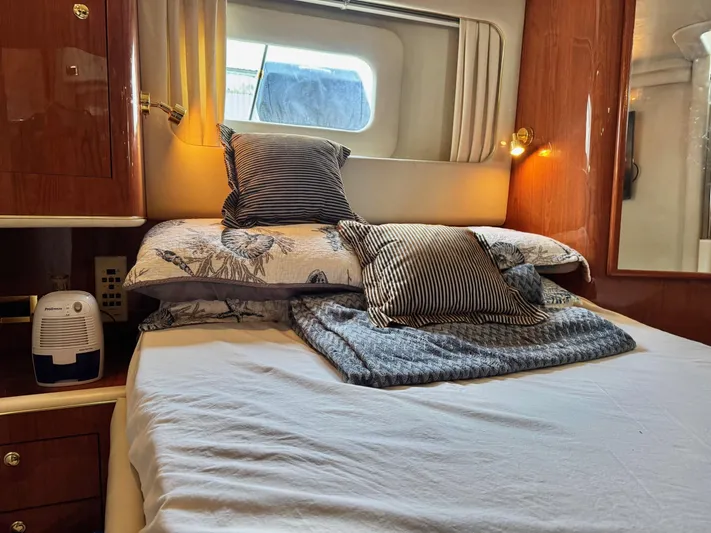  Yacht Photos Pics Cozy bedroom in 1998 Sea Ray 420 Aft Cabin yacht with elegant bedding and wooden accents.