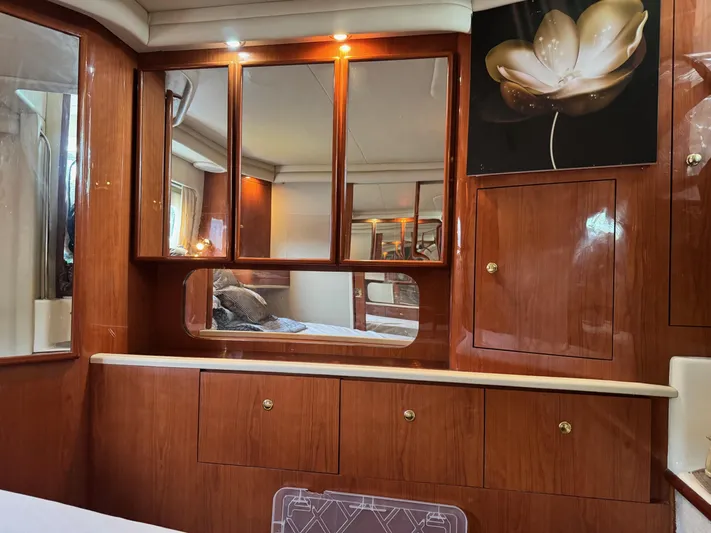  Yacht Photos Pics Interior of 1998 Sea Ray 420 Aft Cabin with wood cabinetry and floral artwork.