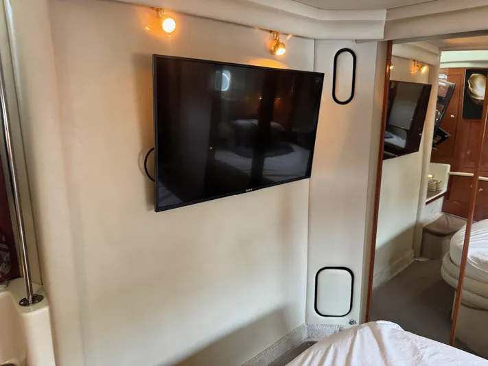  Yacht Photos Pics Interior of 1998 Sea Ray 420 Aft Cabin with mounted TV and cozy lighting.