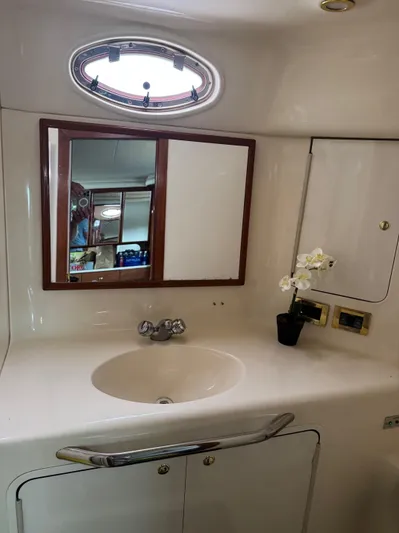  Yacht Photos Pics 1998 Sea Ray 420 Aft Cabin bathroom with sink, mirror, and porthole window.