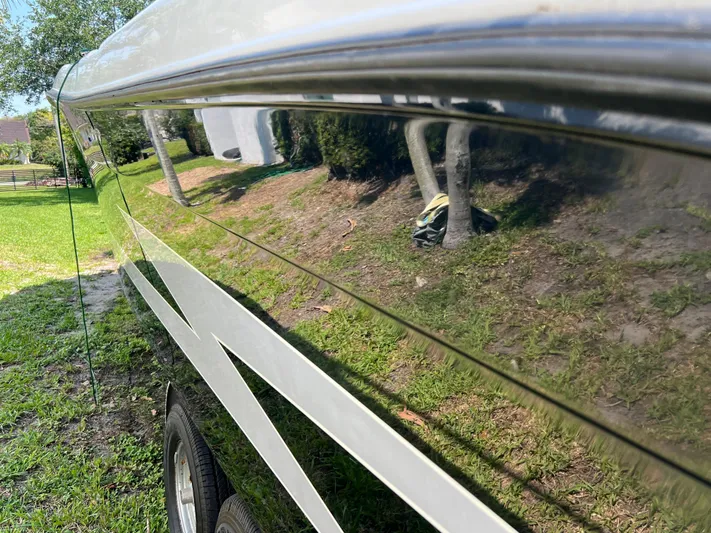  Yacht Photos Pics 2012 Hydra-Sports 3400 CC boat with reflective hull, parked on grass.