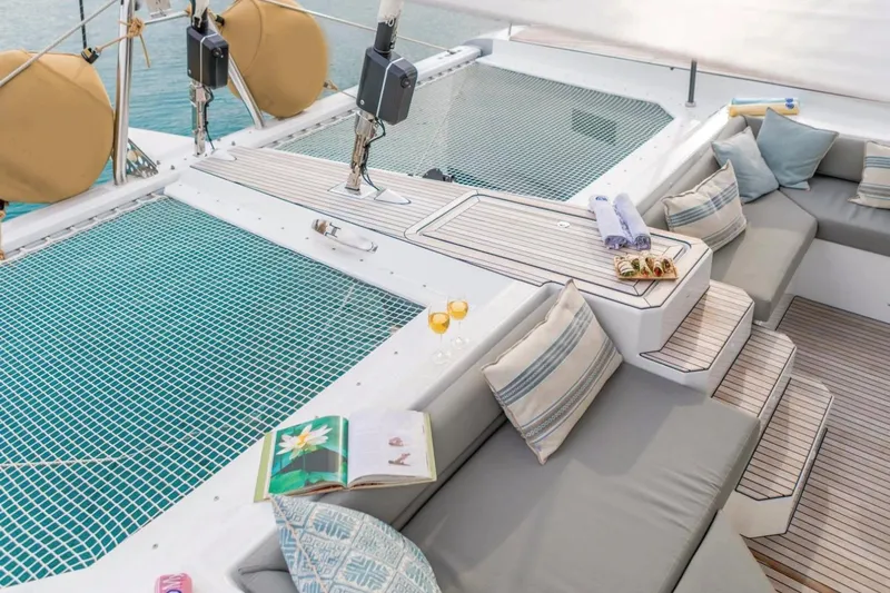  Yacht Photos Pics Luxurious 2021 Fountaine Pajot Samana 59 yacht deck with seating, netting, and refreshments.