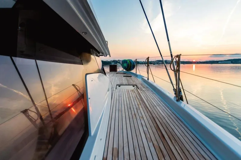  Yacht Photos Pics 2021 Fountaine Pajot Samana 59 yacht deck at sunset, reflecting serene waters.