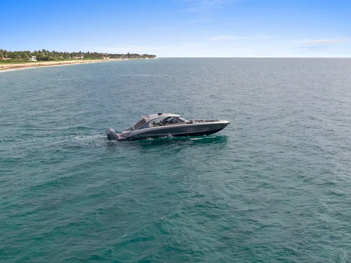  Yacht Photos Pics 2024 Mystic Powerboats M5200 cruising on open water under clear blue skies.