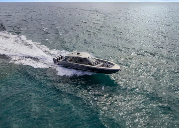  Yacht Photos Pics 2024 Mystic Powerboats M5200 cruising on open water, showcasing sleek design and powerful performance.