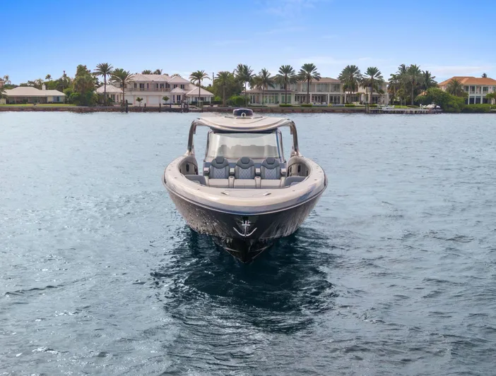  Yacht Photos Pics 2024 Mystic Powerboats M5200 on water, luxury waterfront homes in background.