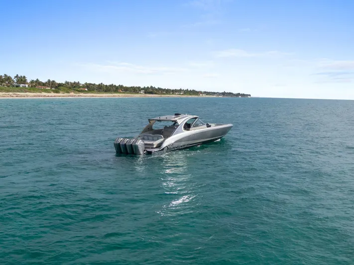  Yacht Photos Pics 2024 Mystic Powerboats M5200 cruising on open water near a scenic coastline.