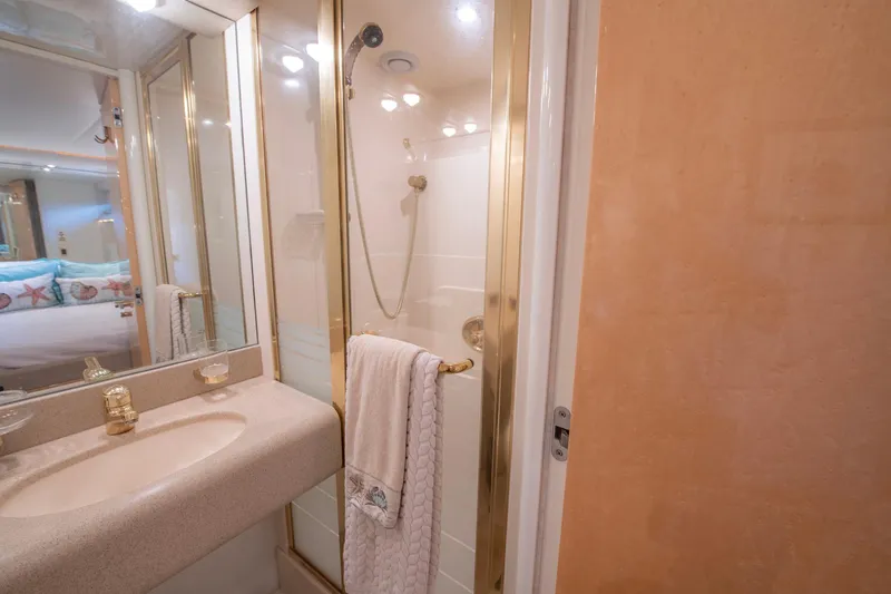 Sea Journey Yacht Photos Pics Luxurious bathroom in 1997 Lazzara 76 Motor Yacht with gold accents and modern fixtures.