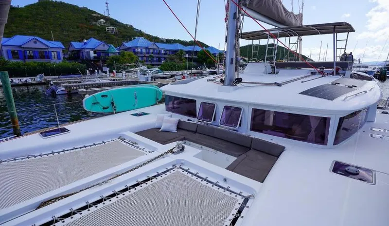 Great Adventure Yacht Photos Pics Lagoon 450 catamaran docked at marina, featuring spacious deck and scenic background.