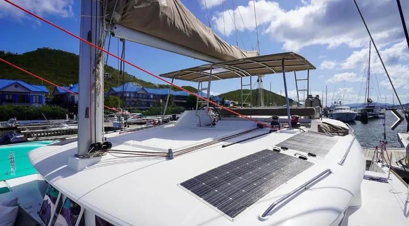 Great Adventure Yacht Photos Pics 2014 Lagoon 450 catamaran with solar panels docked at a marina under a clear sky.