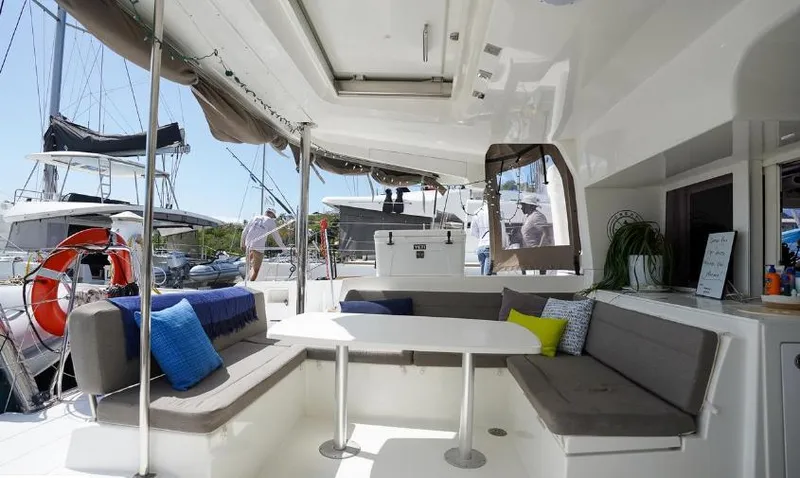 Great Adventure Yacht Photos Pics 2014 Lagoon 450 catamaran interior with seating area, cushions, and table in a marina setting.
