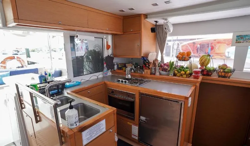 Great Adventure Yacht Photos Pics Modern kitchen interior of 2014 Lagoon 450 yacht with wooden cabinetry and stainless steel appliances.