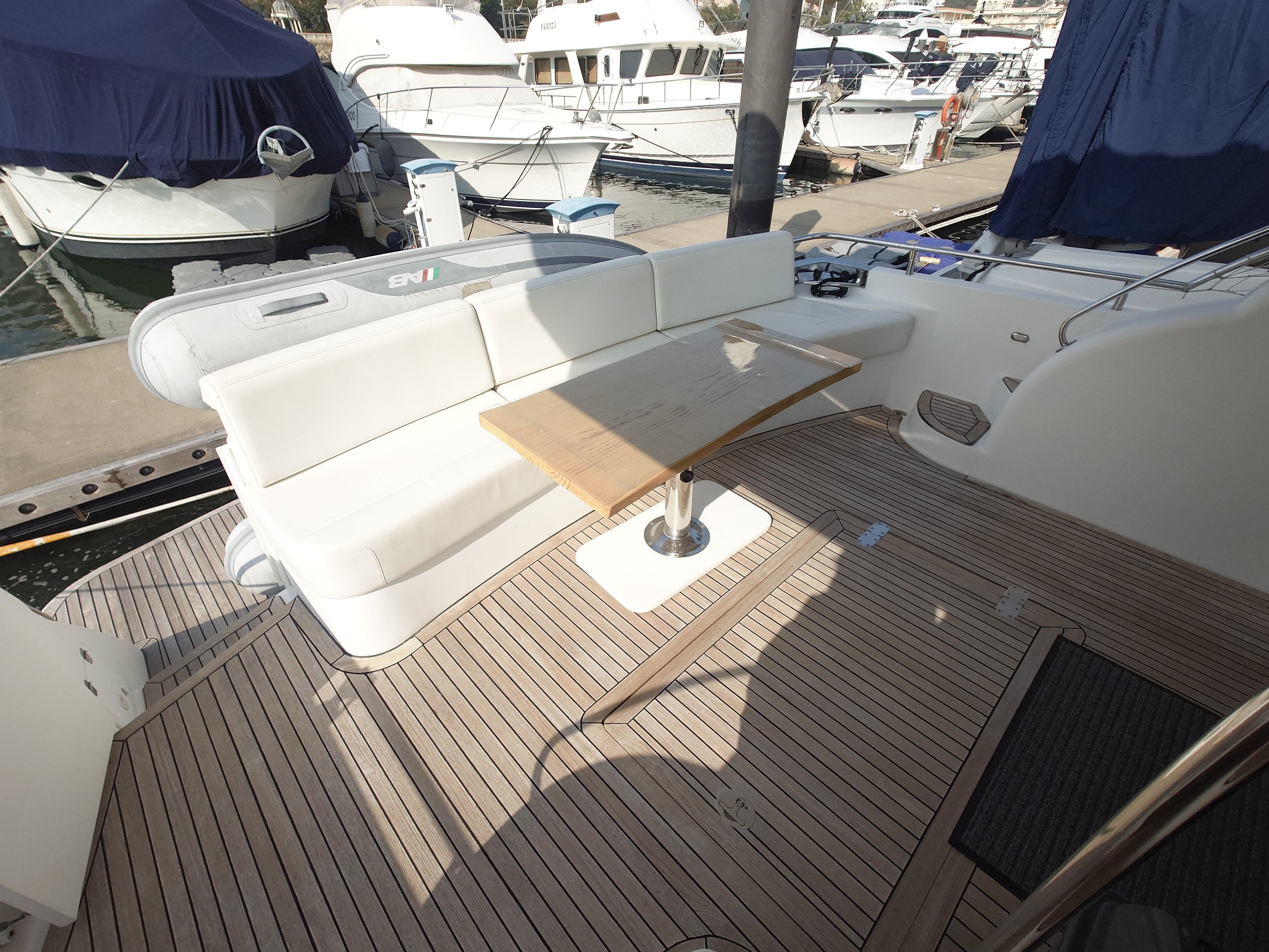 Luxurious Ruby 52 yacht deck with seating and table, docked at marina, 2009 model.
