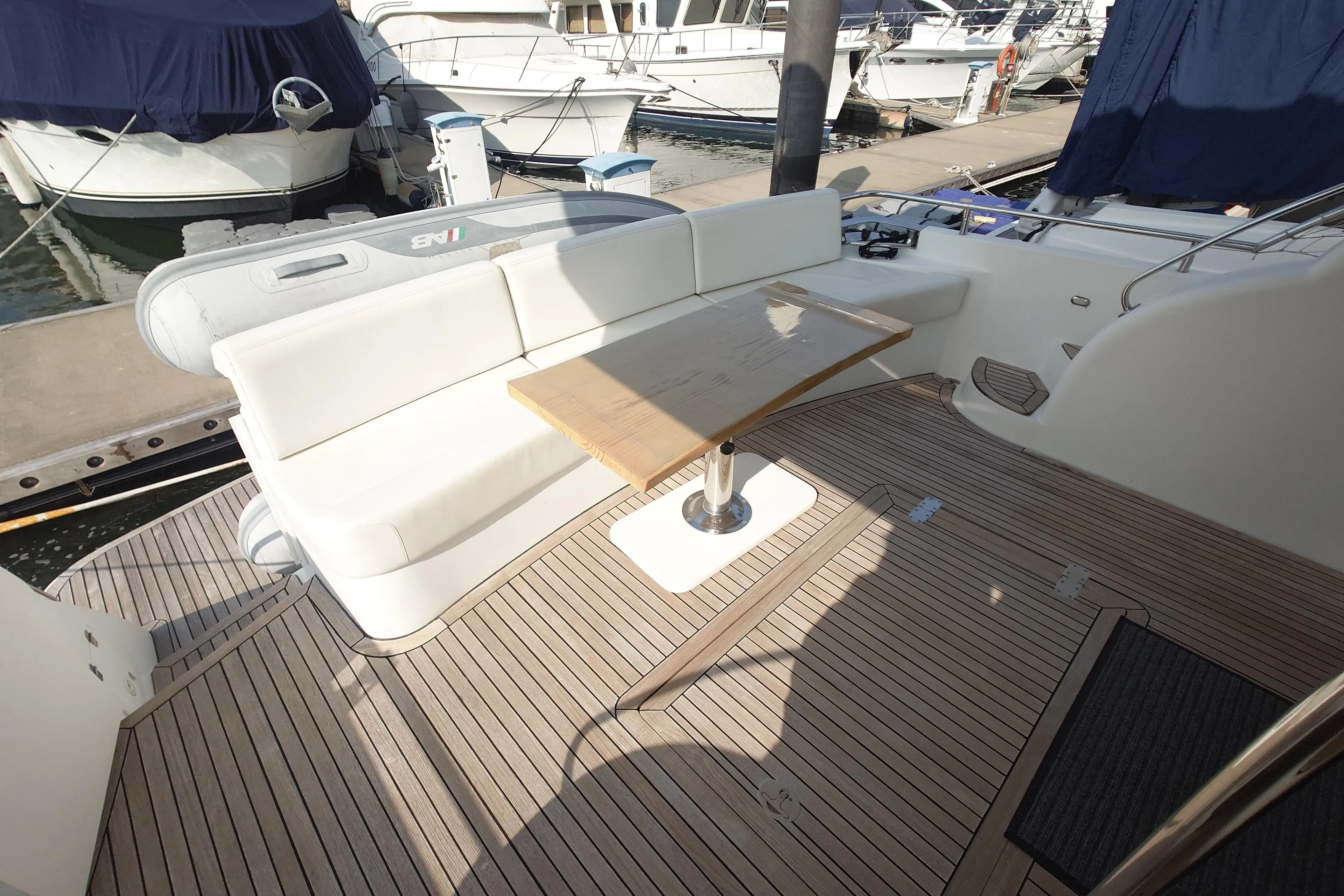 Luxurious Ruby 52 yacht deck with seating and table, docked at marina, 2009 model.