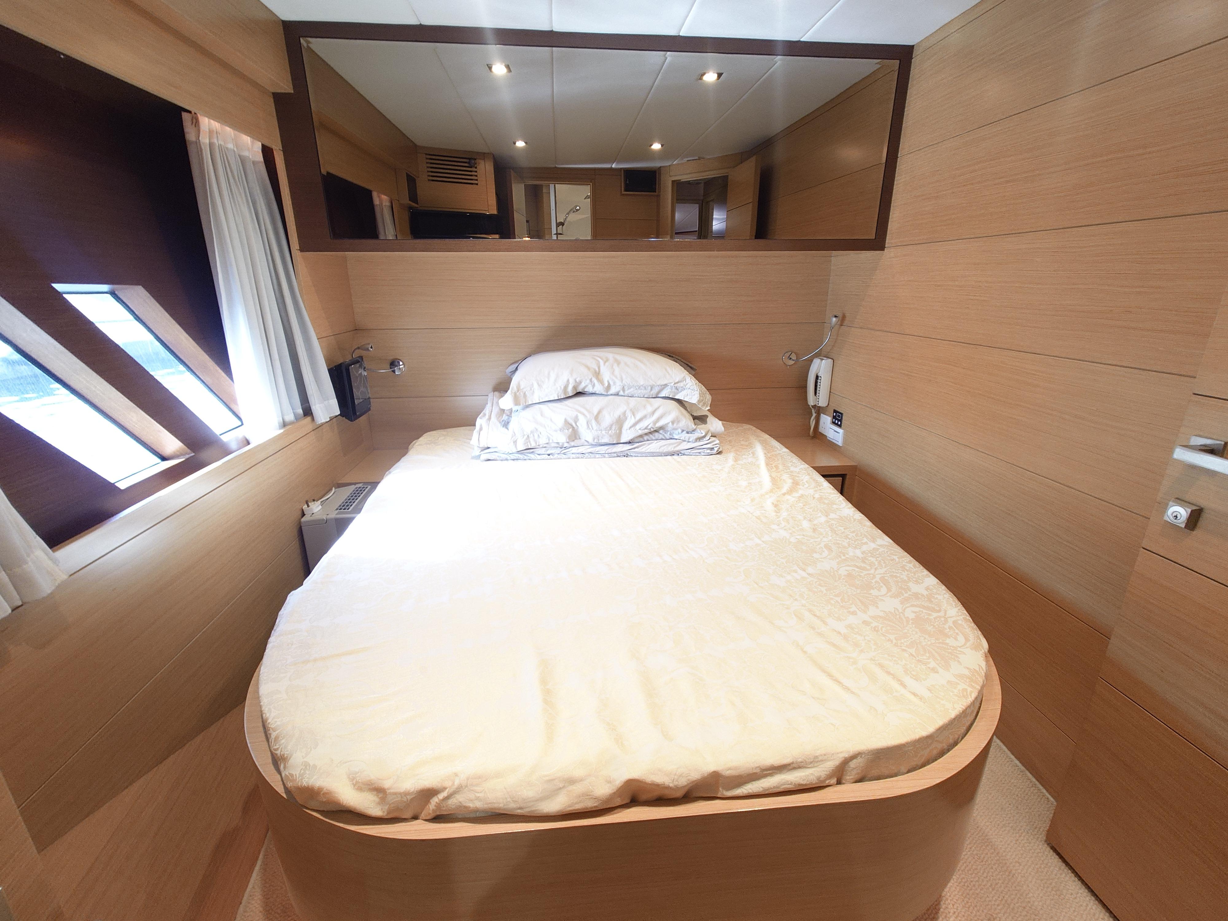 Luxurious bedroom interior on a 2009 Ruby 52 yacht, featuring a cozy bed and modern design.