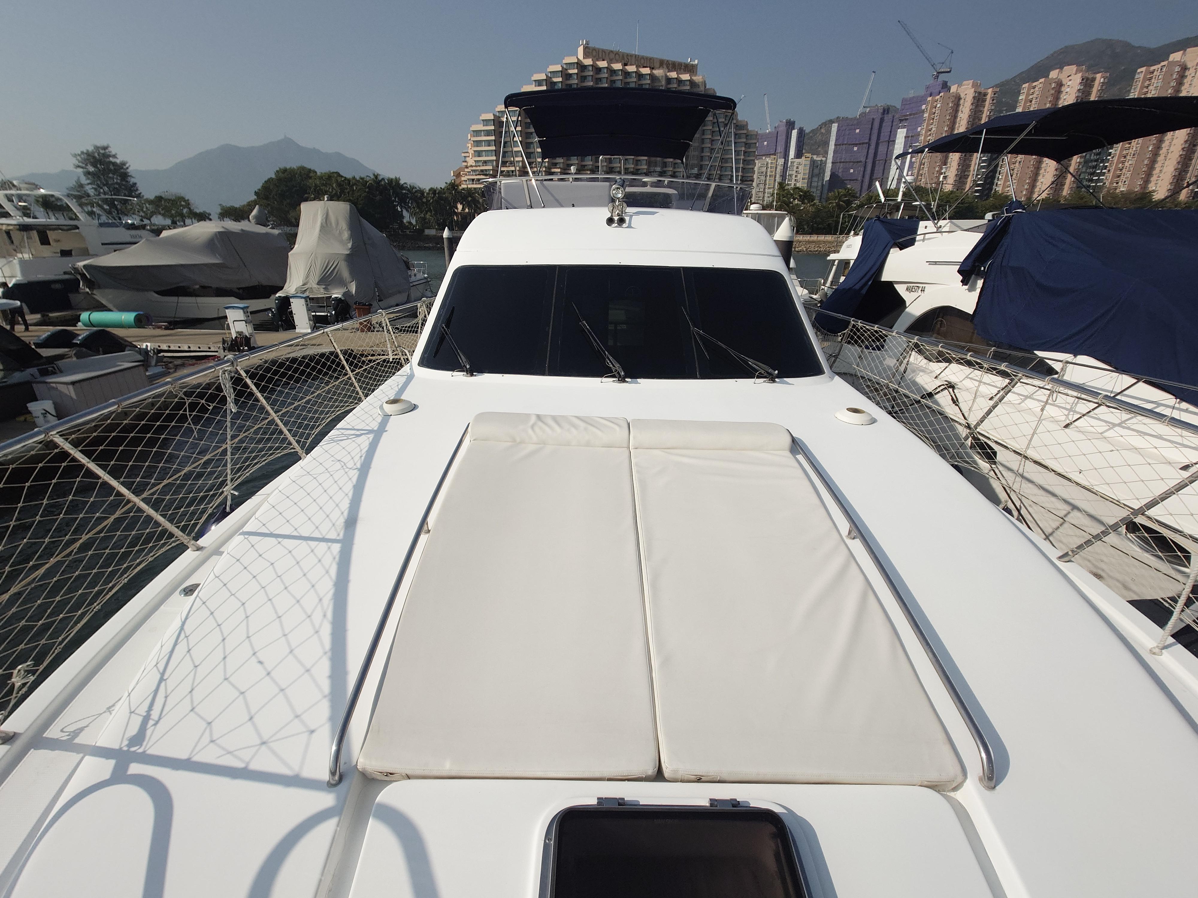 Luxury Ruby 52 yacht docked at marina, 2009 model, with cityscape and mountains in background.
