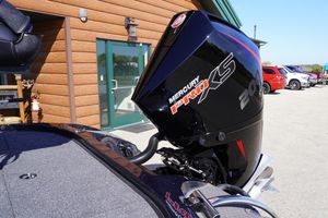 2024 Nitro Z19 boat with Mercury Pro XS 200 engine, parked outside a wooden building.