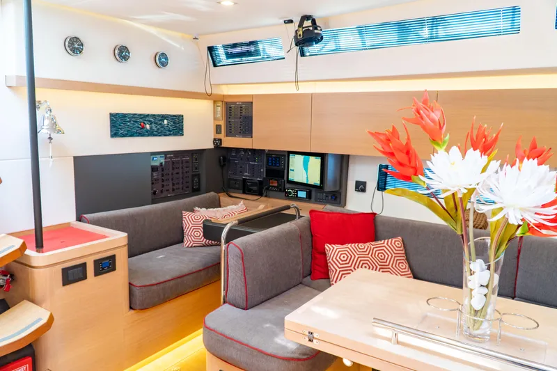  Yacht Photos Pics Interior of 2018 Amel 50 yacht with modern seating, navigation equipment, and floral centerpiece.