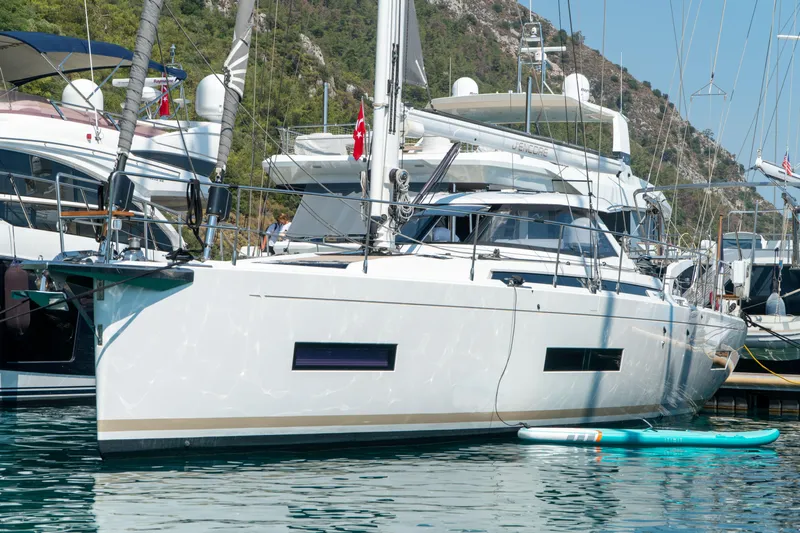  Yacht Photos Pics Sailing yacht Amel 50, 2018 model, docked in a marina with paddleboard nearby.