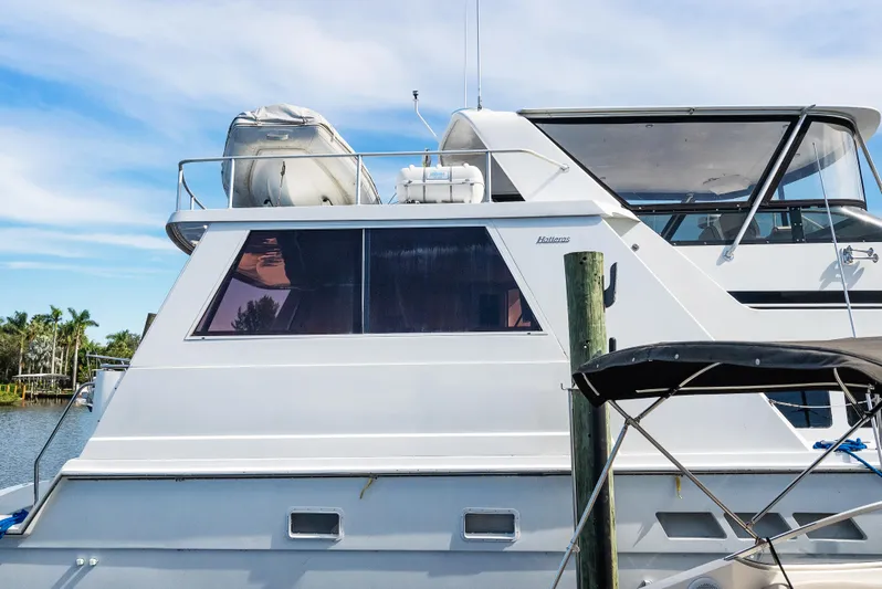  Yacht Photos Pics 1998 Hatteras 52 Cockpit Motor Yacht docked, featuring sleek design and spacious upper deck.