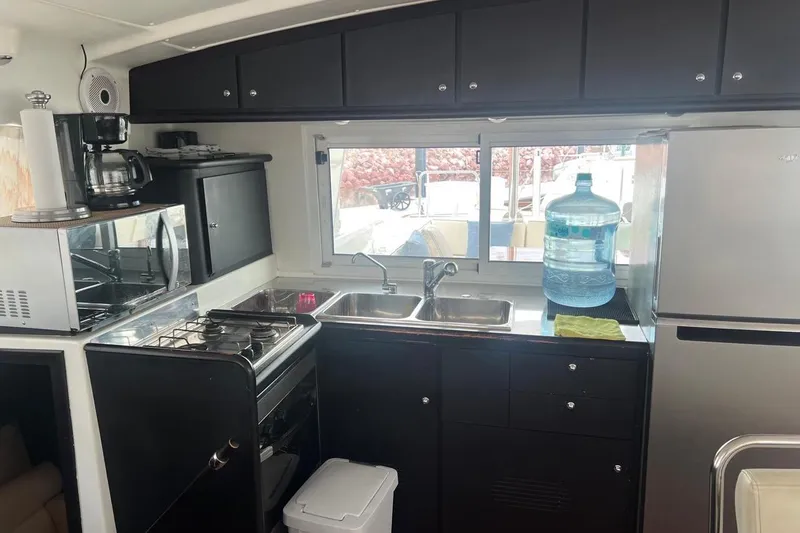 Queen Butterfly Yacht Photos Pics Interior kitchen of 2006 Lagoon 440 yacht with modern appliances and large window.