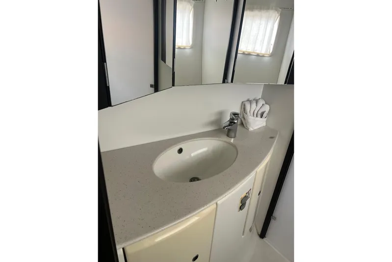 Queen Butterfly Yacht Photos Pics Bathroom sink area in 2006 Lagoon 440 yacht, featuring modern fixtures and a mirror.