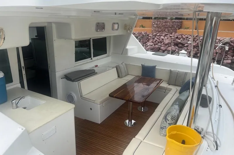 Queen Butterfly Yacht Photos Pics Spacious 2006 Lagoon 440 yacht interior with seating, table, and kitchenette.
