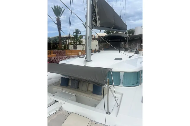 Queen Butterfly Yacht Photos Pics 2006 Lagoon 440 catamaran with spacious deck and seating area, docked near palm trees.