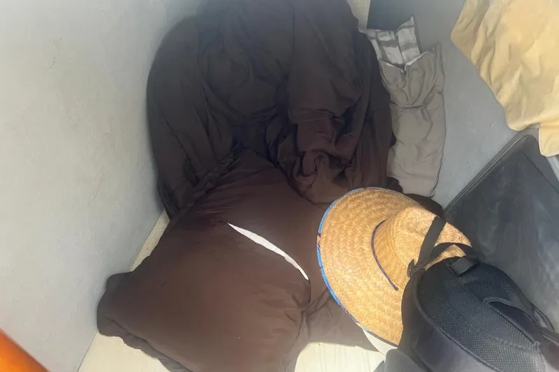 Queen Butterfly Yacht Photos Pics Cozy sleeping area with brown bedding and a straw hat on a Lagoon 440, 2006 model.