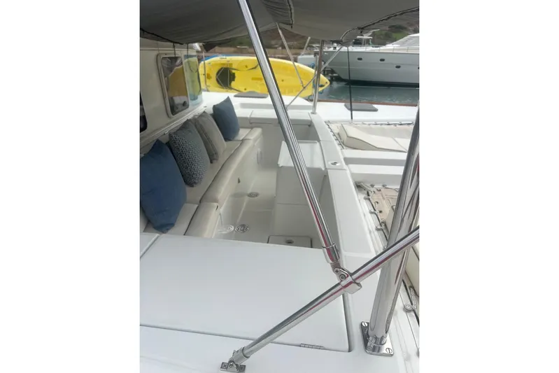 Queen Butterfly Yacht Photos Pics 2006 Lagoon 440 catamaran with cushioned seating and canopy, docked near other boats.