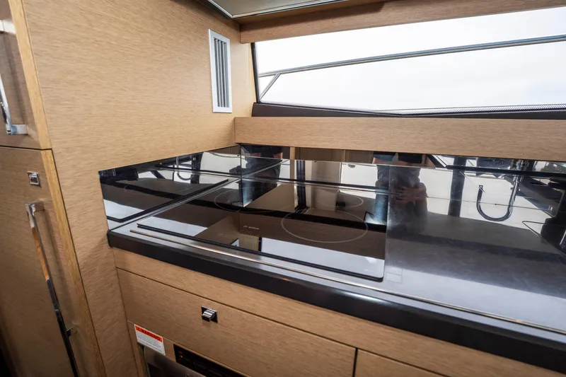 Seeworthy Yacht Photos Pics Modern kitchen area in a 2018 Prestige 560 yacht with sleek appliances and wood finish.