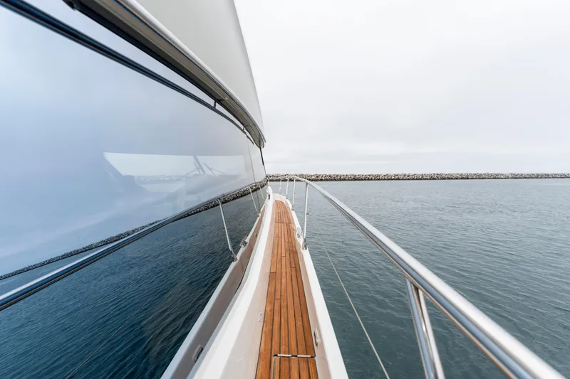 Seeworthy Yacht Photos Pics Side view of 2018 Prestige 560 yacht on calm water, showcasing sleek design and wooden deck.