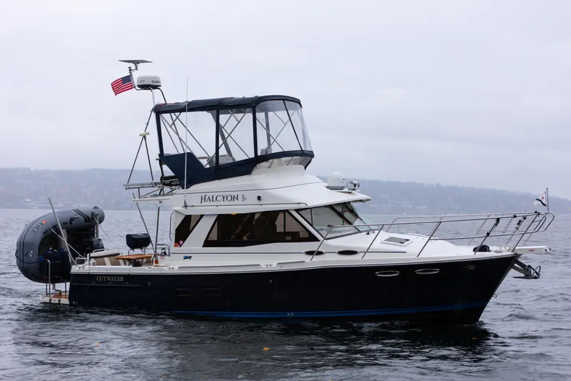 Halcyon Yacht Photos Pics 2016 Cutwater 30 CB boat on water, featuring a flybridge and American flag.