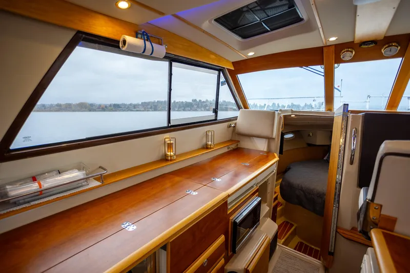 Halcyon Yacht Photos Pics Interior of 2016 Cutwater 30 CB boat with wood finishes and large windows.