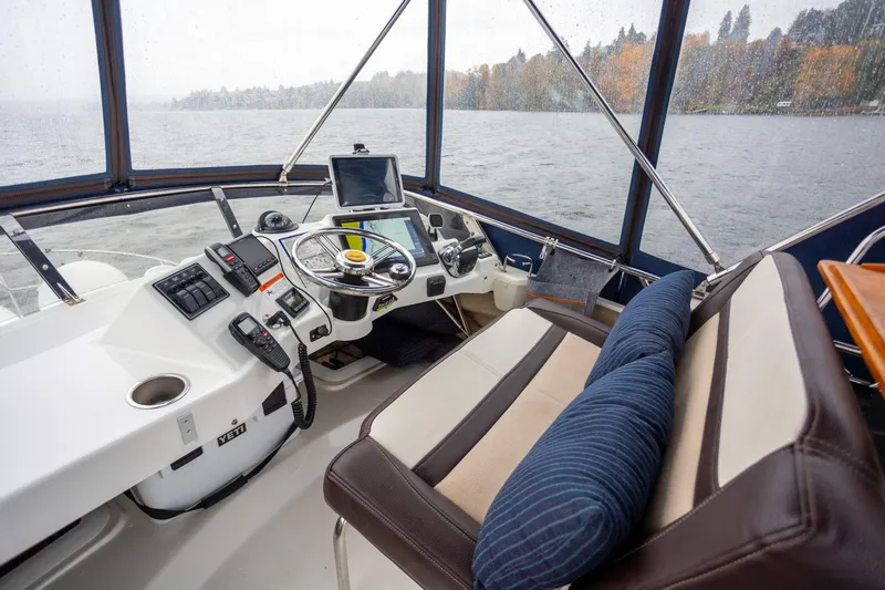 Halcyon Yacht Photos Pics Interior view of 2016 Cutwater 30 CB boat cockpit with steering wheel and navigation equipment.