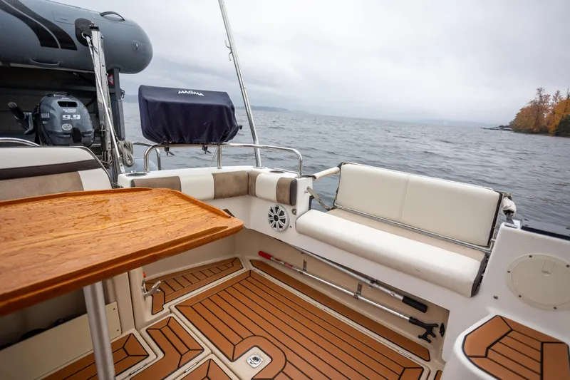 Halcyon Yacht Photos Pics 2016 Cutwater 30 CB boat interior with wooden table, seating, and Yamaha outboard motor.