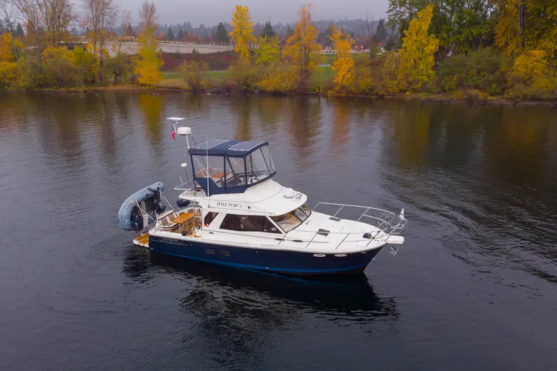 Halcyon Yacht Photos Pics 2016 Cutwater 30 CB boat on calm water with autumn trees in the background.
