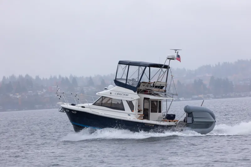 Halcyon Yacht Photos Pics 2016 Cutwater 30 CB boat cruising on a misty lake with American flag.