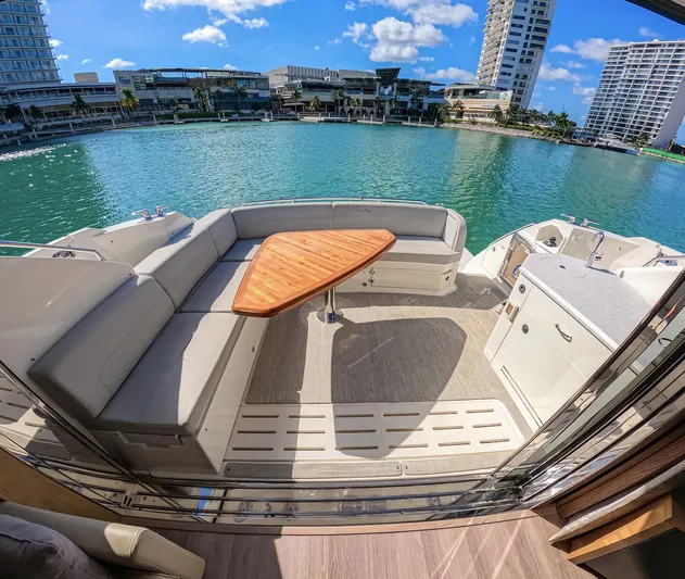  Yacht Photos Pics Luxurious 2018 Sea Ray L590 yacht deck with seating, table, and waterfront view.
