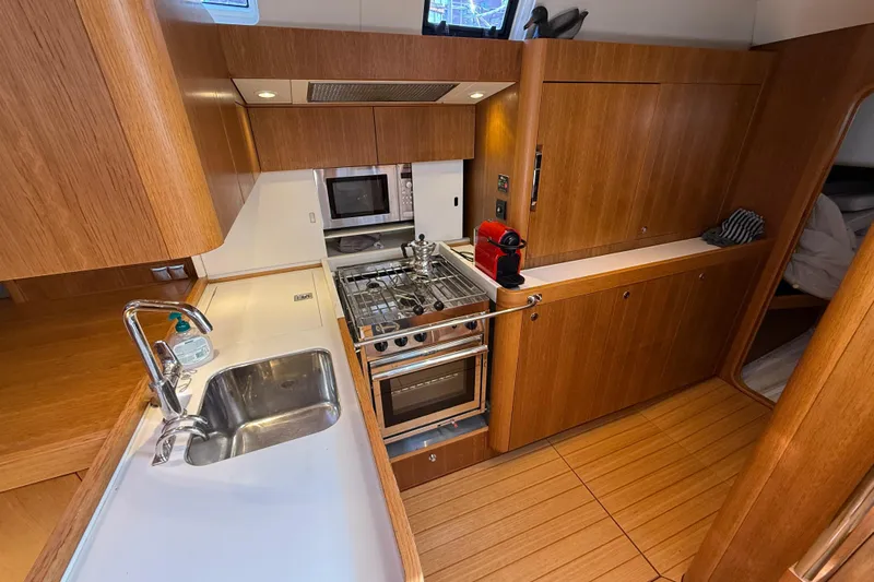 Pau Hana Yacht Photos Pics Luxurious 2019 Nautor Swan 54 yacht kitchen with modern appliances and wooden cabinetry.